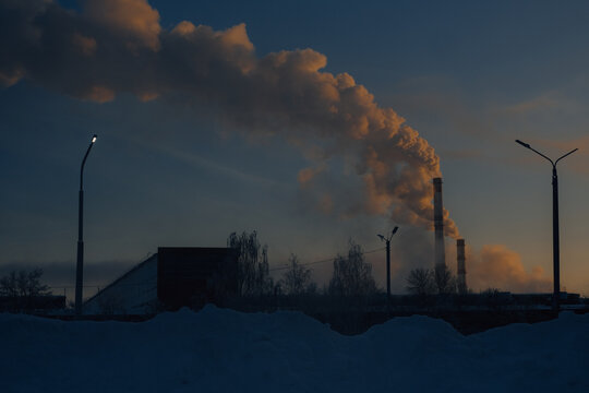 industrial plant with smoke at dawn