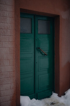 green double door with snow