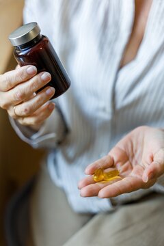 Woman Holding Capsules In Hand
