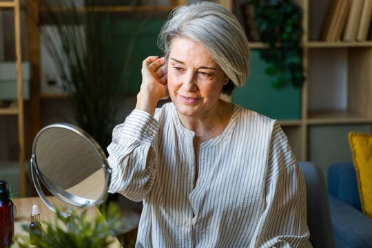Woman Checking Skin In Mirror