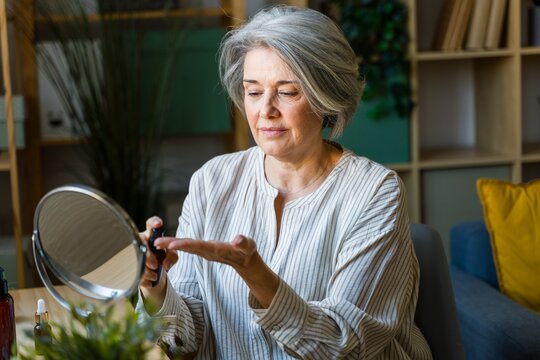 Woman Applying Serum In Living Room