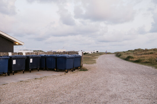 trash bins at side of gravel road at campground in denmark