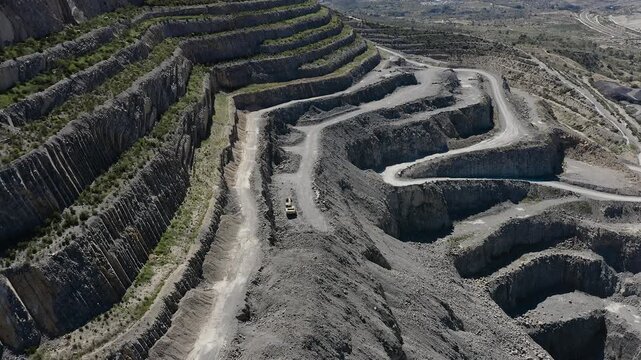 Aerial view of a cement quarry with special vehicles assisting in rock extraction in Spain.