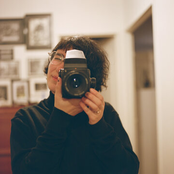 Casual self portrait of a woman photographer in a mirror.