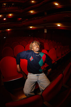 Person sits in empty theater during evening performance
