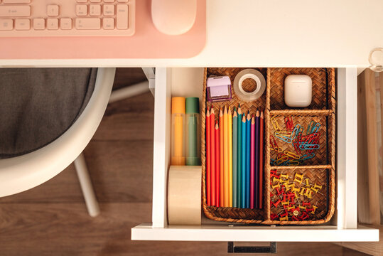 Top view of a neat desk drawer filled with office supplies.