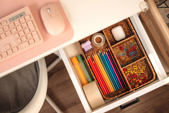 Top view of a neat desk drawer filled with office supplies.