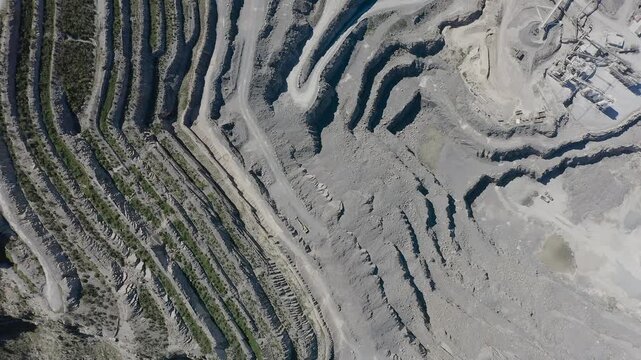Aerial view of a cement quarry with special vehicles assisting in rock extraction in Spain.