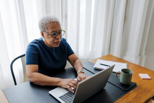 Senior woman typing on laptop working from home