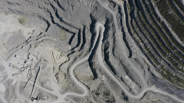 Aerial view of a cement quarry with special vehicles assisting in rock extraction in Spain.