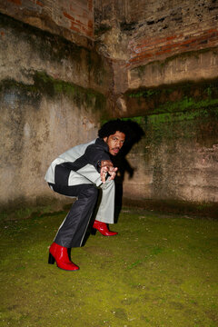 Model Poses in Urban Setting Wearing Stylish Outfit and Red Boots