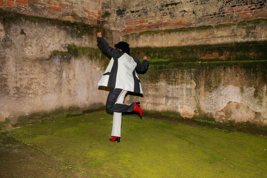 Person Dances in Trendy Clothing and Red Shoes