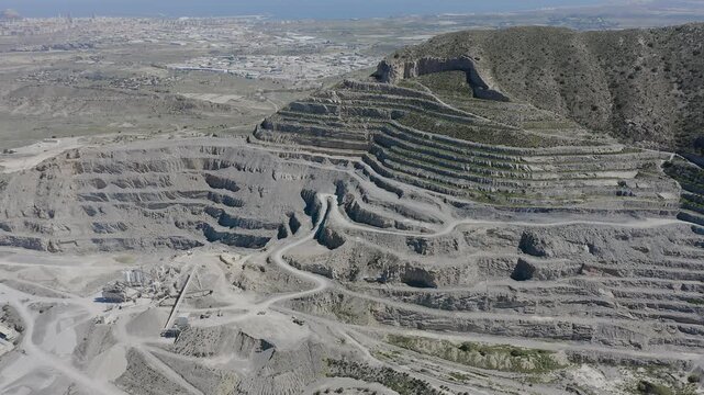 Aerial view of a cement quarry with special vehicles assisting in rock extraction in Spain.