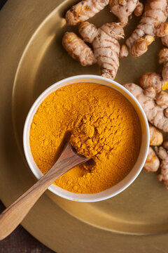 Turmeric Powder and Root on a Tray for Cooking and Health Benefits