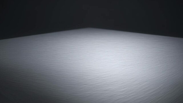Minimalistic perspective shot showcasing a gray rippled surface against a dark background