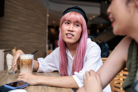 Friends chatting over iced coffee at a cafe.