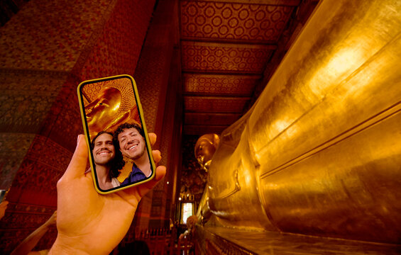 Smartphone selfie with reclining Buddha statue in Bangkok temple