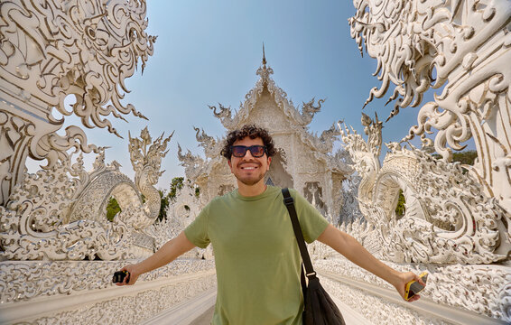 Tourist posing with arms open at White Temple Chiang Rai