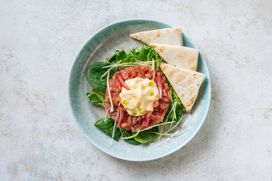 Tuna tartare with greens, mayonnaise, and toast triangles