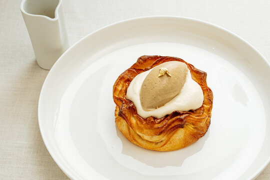 Pastry dessert with cream and ice cream on white plate