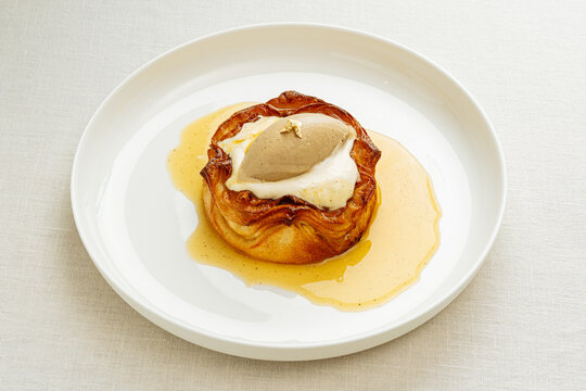Apple pastry with cream and ice cream on white plate