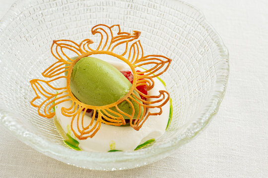 Green sorbet dessert with whipped cream and decorative tuile