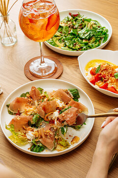 Mixed lunch with prosciutto salad, greens, appetizer, and strawberry c