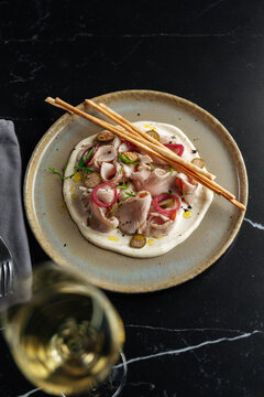 Sliced veal with cream, pickled onions, and breadsticks 