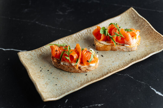 Smoked salmon crostini with cream cheese and arugula