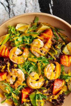 Shrimp salad with avocado, tomato, greens, and dressing