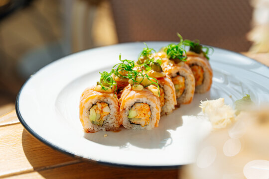 Sushi rolls with avocado, sauce, and scallions