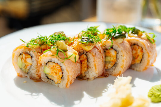 Salmon sushi rolls with avocado and spicy filling