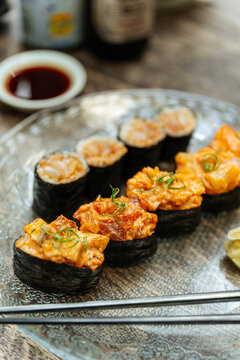 Spicy gunkan and maki sushi on glass plate
