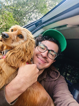 Man hugging dog while sitting in car