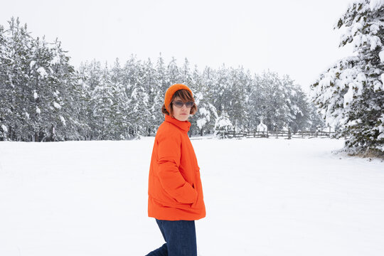 Portrait Of Woman In Orange Winter Jacket With Sunglasses Walking 