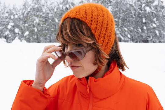 Portrait Of Woman In Orange Winter Jacket With Sunglasses