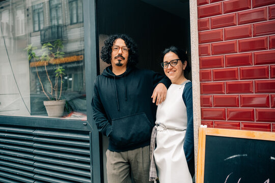 Couple Stands Outside of Cafe in Busy City During Daytime