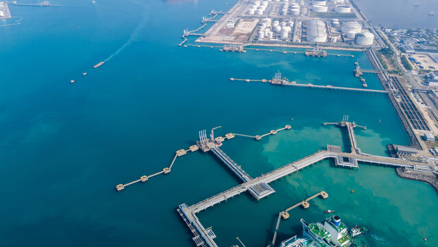 Massive LNG storage tank facility at an industrial coastal terminal. Global natural gas energy logistics, liquid fuel cargo container supply chain, and petroleum distribution trade concept.