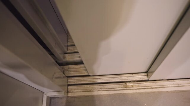 Worn sliding door threshold closeup showing corroded metal track, concrete floor, scuff marks and grime multiple angles reveal seal gaps, misalignment and buildup, ideal for repair, restoration