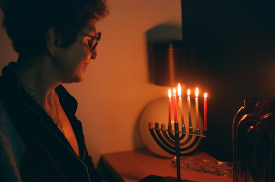 Woman lighting up Hanukah candles