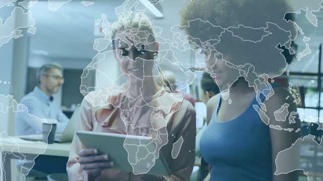 Two women reviewing tablet in office scrolling and causing soft world map overlay for marketing