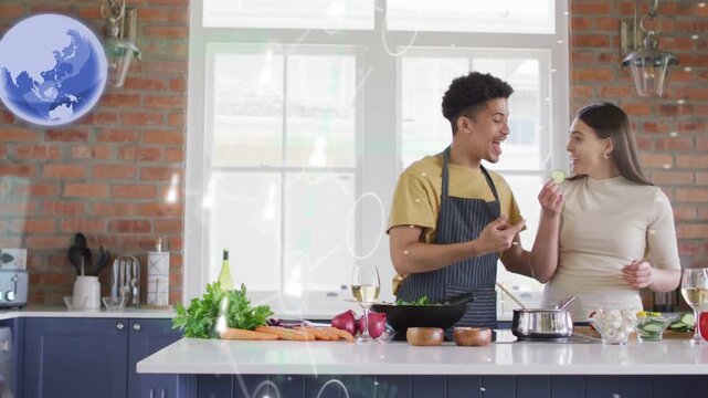 Couple cooking in kitchen, man reaching offering bite for tasting while globe nodes spreading