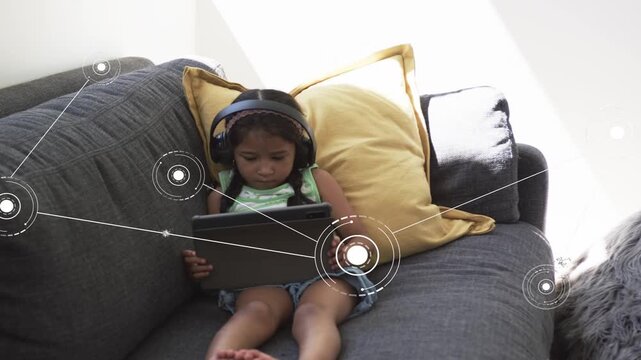 Child sitting on sofa holding tablet, using education app causing HUD rings expanding across frame