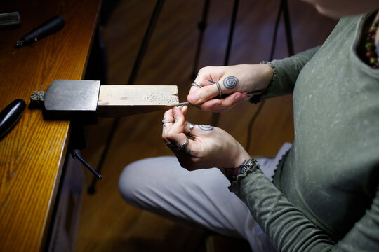 a woman makes jewelry