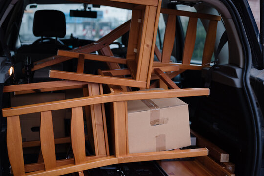 Car Filled With Wooden Chairs and Boxes During a Busy Day