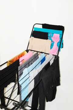 Colourful laundry clothes on a drying rack with direct flashlight