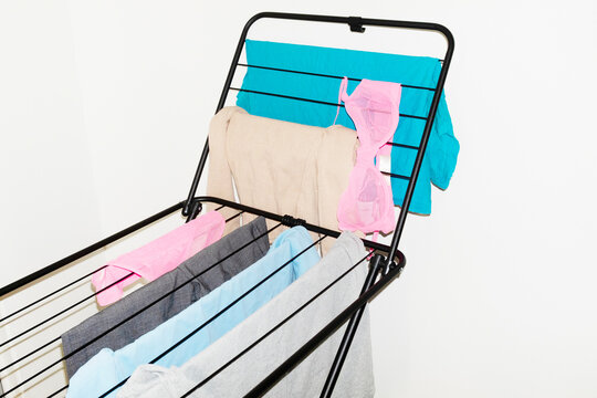 Colourful laundry clothes on a drying rack with direct flashlight