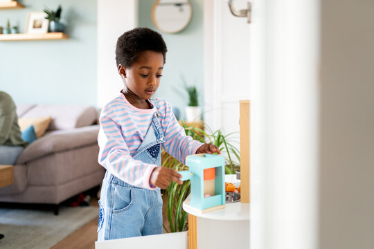 Child playing with toy kitchen learning new skills