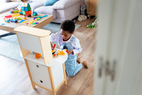 Child playing with toy kitchen learning new skills