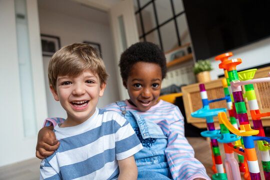 Diverse children friends playing with marble run together